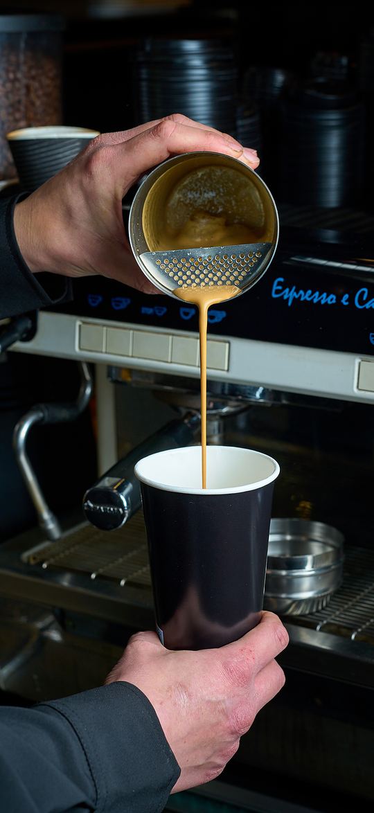 Ο barista σερβίρει φρέντο εσπρέσο από το σέικερ σε ποτήρι Mornings